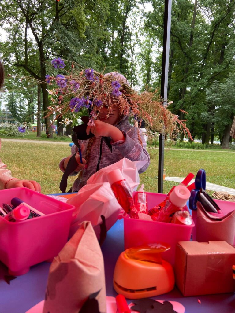 dziewczynka w trakcie wycinania z wiankiem z kwiatów na głowie