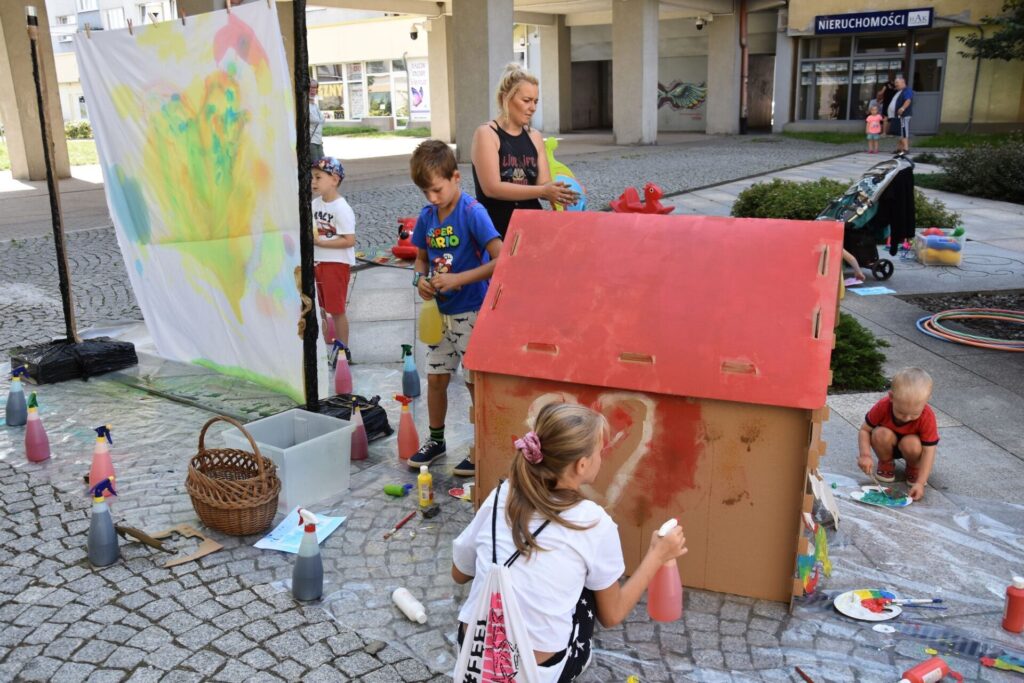 Dzieci na skwerze z dzikami malują eko farbami