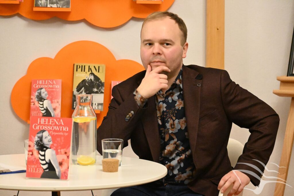 Marek Teler siedzi podczas spotkania autorskiego.